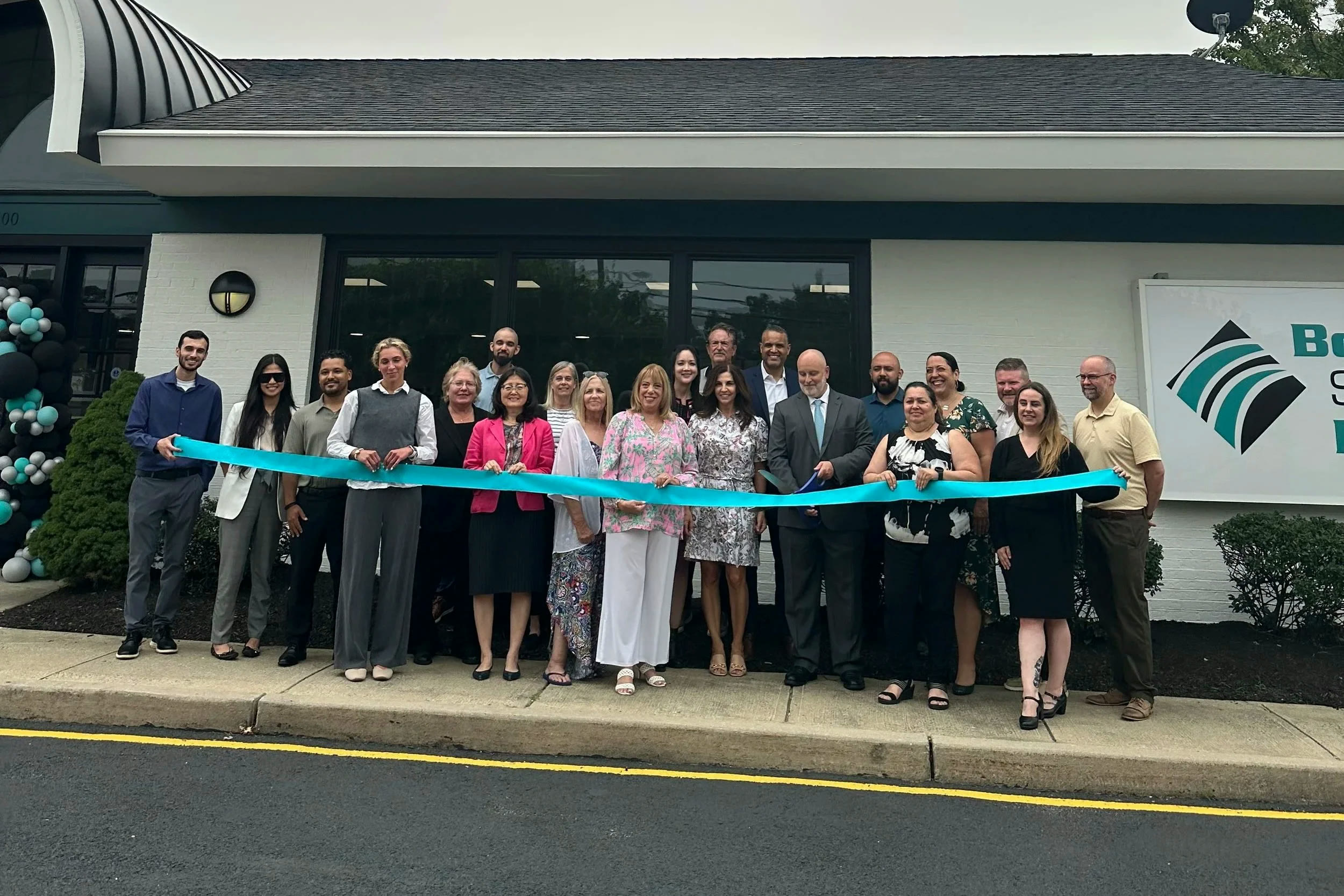 The Bogota Savings Bank team cutting a teal ribbon outside the new Point Pleasant branch